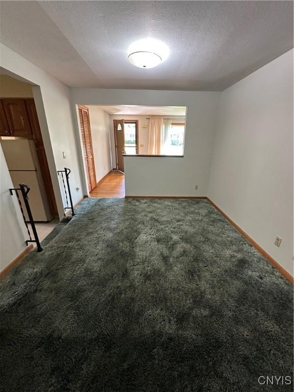 9385 Wickham Dr, Cicero, NY 13029 - unfurnished room featuring light carpet, baseboards, and a textured ceiling