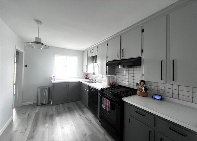 305 S Hoffman St, Elmira-City, NY 14904 - kitchen featuring black appliances, under cabinet range hood, a sink, light wood-style flooring, and backsplash