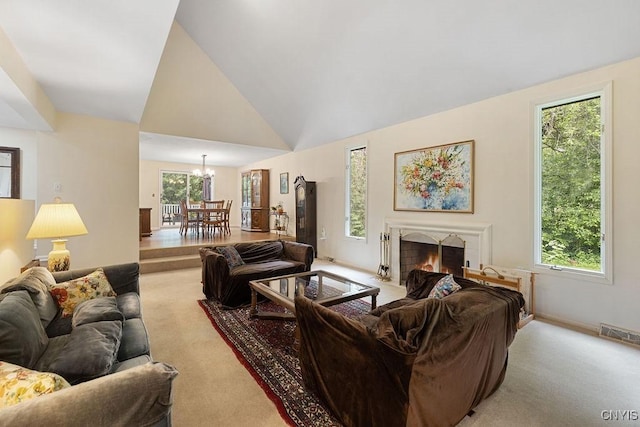4962 Tall Oaks Dr, Manlius, NY 13066 - carpeted living room featuring a lit fireplace, a chandelier, and high vaulted ceiling