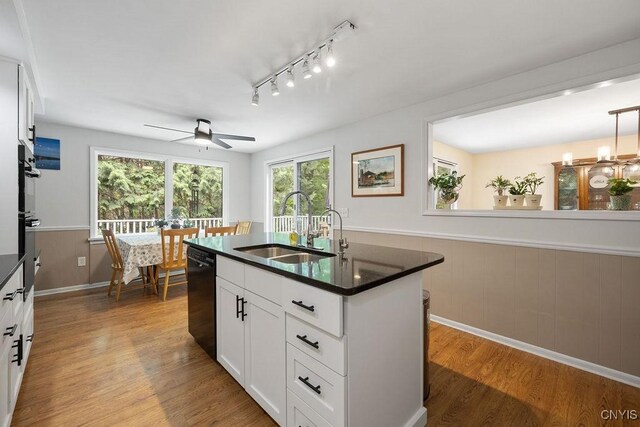 4962 Tall Oaks Dr, Manlius, NY 13066 - kitchen with dark countertops, wood finished floors, a ceiling fan, black dishwasher, and healthy amount of natural light