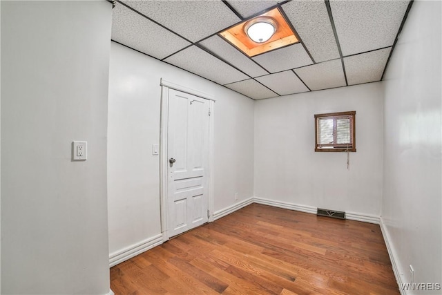 421 E Utica St, Buffalo, NY 14208 - empty room featuring a drop ceiling, baseboards, and wood finished floors