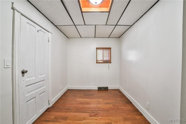 421 E Utica St, Buffalo, NY 14208 - unfurnished bedroom featuring wood finished floors, a paneled ceiling, and baseboards
