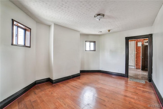 421 E Utica St, Buffalo, NY 14208 - empty room featuring hardwood / wood-style flooring, a textured ceiling, and baseboards