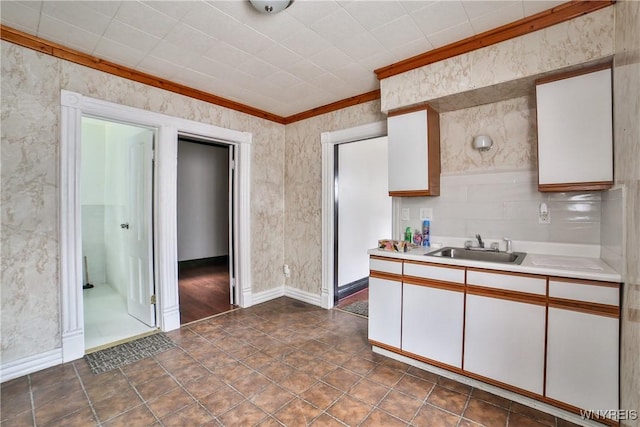 421 E Utica St, Buffalo, NY 14208 - kitchen with a sink, ornamental molding, light countertops, white cabinetry, and baseboards