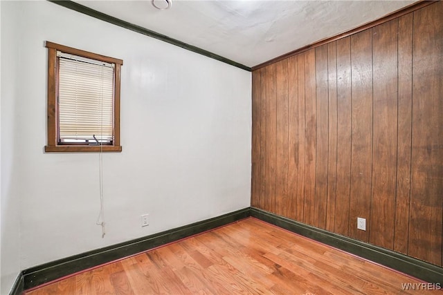 421 E Utica St, Buffalo, NY 14208 - empty room featuring wood finished floors, ornamental molding, wood walls, and baseboards