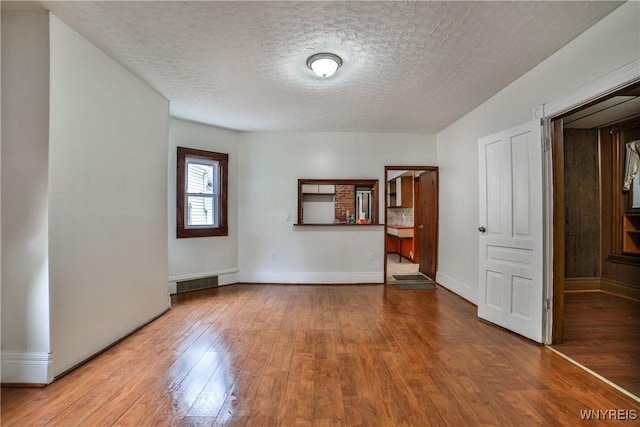 421 E Utica St, Buffalo, NY 14208 - spare room with hardwood / wood-style floors, a textured ceiling, and baseboards