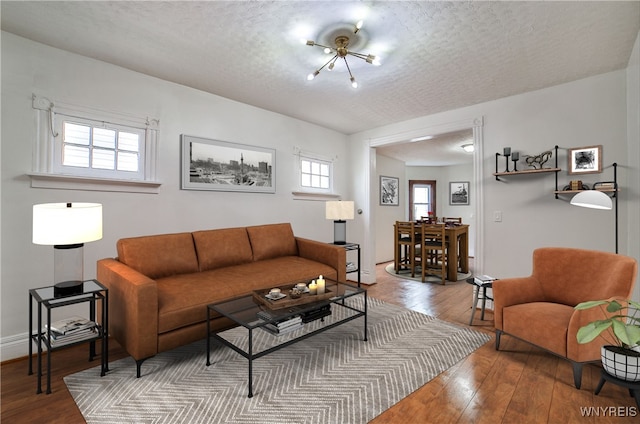 421 E Utica St, Buffalo, NY 14208 - living area featuring hardwood / wood-style floors, a textured ceiling, and a chandelier