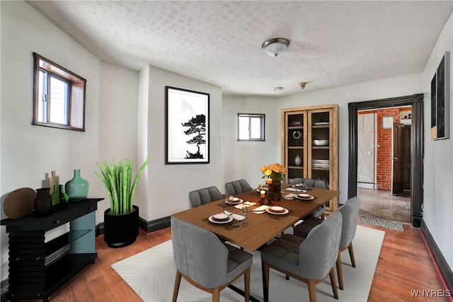 421 E Utica St, Buffalo, NY 14208 - dining space featuring a textured ceiling, baseboards, and wood finished floors