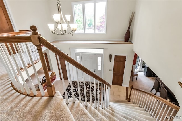 8395 Black Walnut Dr, Clarence, NY 14051 - stairway featuring a chandelier, tile patterned floors, and a high ceiling