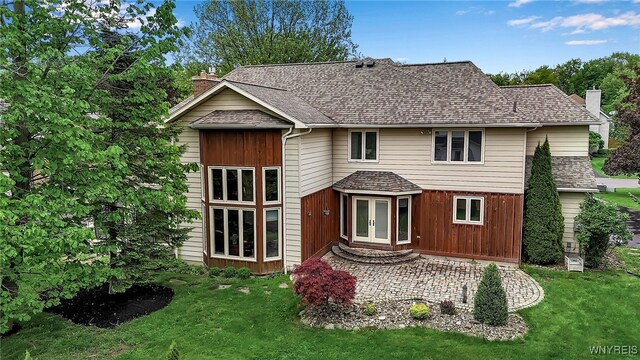 8395 Black Walnut Dr, Clarence, NY 14051 - rear view of house with a chimney, french doors, a lawn, a shingled roof, and a patio