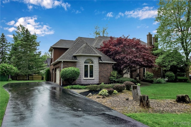 8395 Black Walnut Dr, Clarence, NY 14051 - french country home with driveway, brick siding, a chimney, and roof with shingles