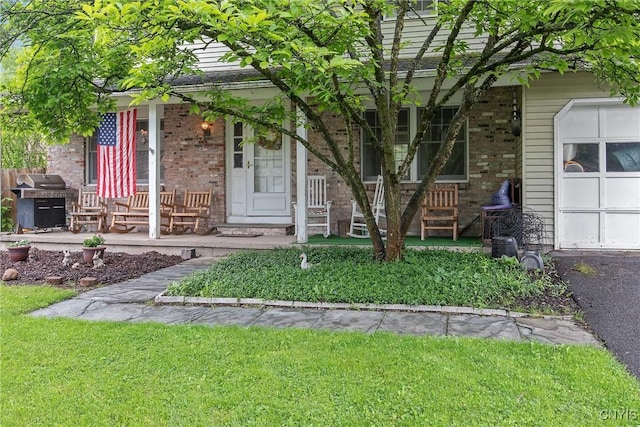8013 Plinius, Clay, NY 13090 - doorway to property with covered porch, brick siding, a garage, and a yard