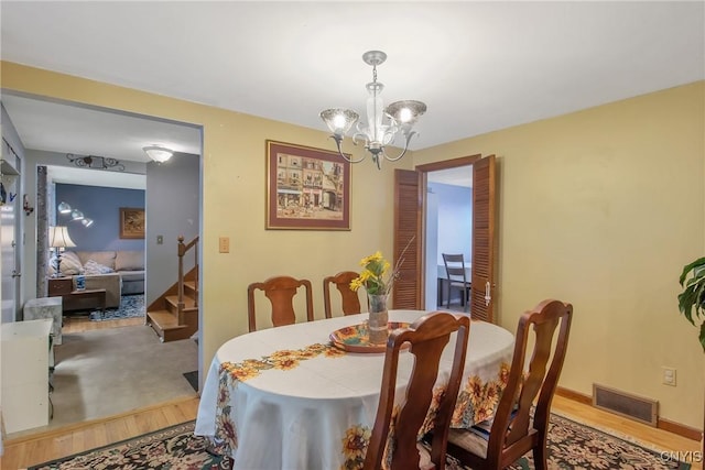 8013 Plinius, Clay, NY 13090 - dining space featuring wood finished floors, a chandelier, and stairway