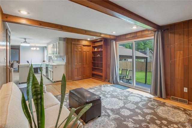 8013 Plinius, Clay, NY 13090 - living room featuring light wood-style flooring, beam ceiling, and wood walls
