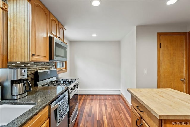 79 Windermere Blvd, Amherst, NY 14226 - kitchen with stainless steel appliances, baseboard heating, decorative backsplash, dark wood-style flooring, and recessed lighting