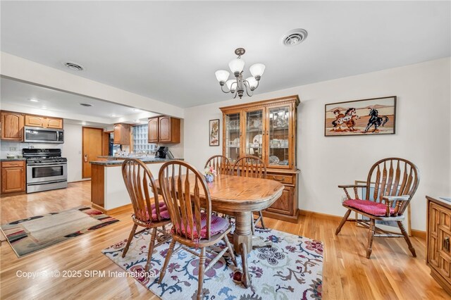 393 Bauman Rd, Amherst, NY 14221 - dining area featuring light wood-type flooring, a chandelier, and baseboards