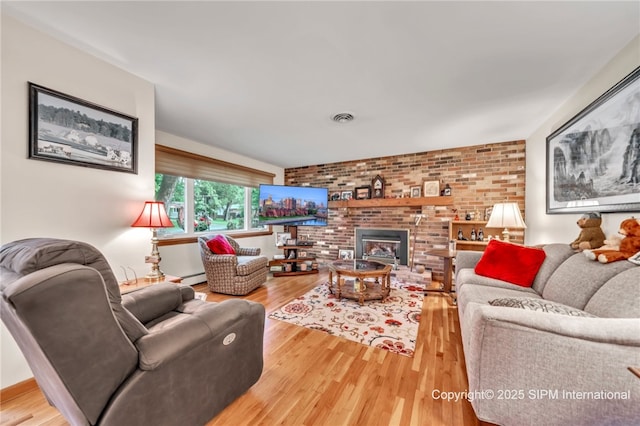 393 Bauman Rd, Amherst, NY 14221 - living room featuring wood finished floors, brick wall, a brick fireplace, and baseboard heating