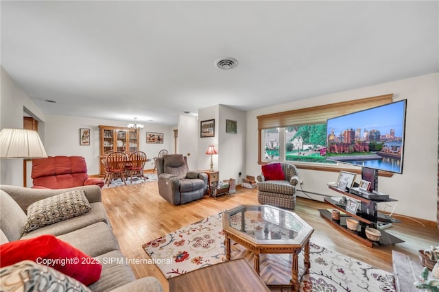 393 Bauman Rd, Amherst, NY 14221 - living room with a chandelier, a baseboard heating unit, and wood finished floors