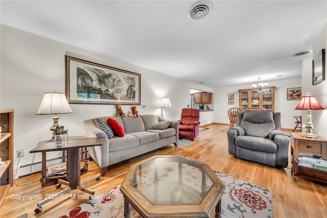 393 Bauman Rd, Amherst, NY 14221 - living area with light wood finished floors, a chandelier, a baseboard radiator, and baseboards