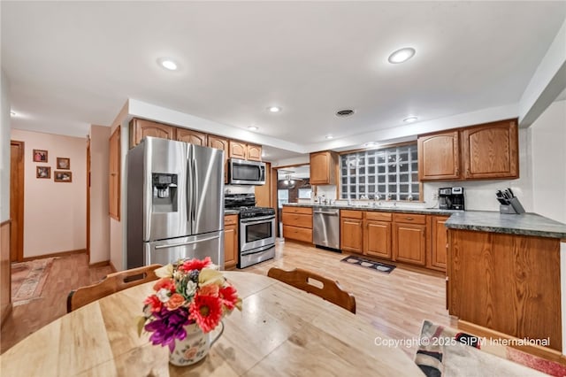 393 Bauman Rd, Amherst, NY 14221 - kitchen with appliances with stainless steel finishes, brown cabinetry, light wood-style flooring, recessed lighting, and baseboards