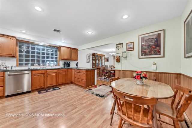 393 Bauman Rd, Amherst, NY 14221 - kitchen featuring dishwasher, a wainscoted wall, dark countertops, light wood finished floors, and a sink