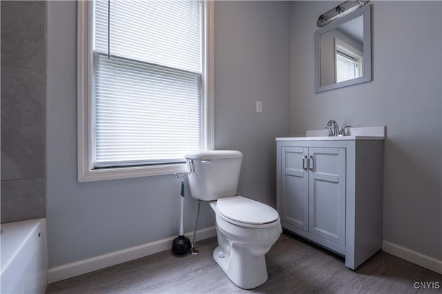 611 Turin St, Rome-Inside, NY 13440 - bathroom featuring wood finished floors, vanity, a tub to relax in, toilet, and baseboards