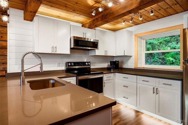 1159 Hunt Rd, Forestport, NY 13494 - kitchen featuring stainless steel appliances, a sink, wood ceiling with exposed beams, dark countertops, and rail lighting