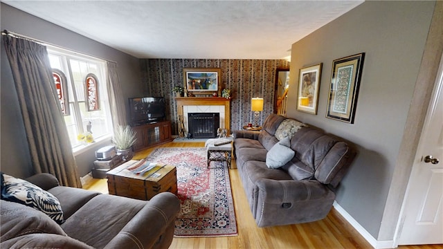 7404 Bonney Hill Rd, Hamilton, NY 13346 - living area with wood finished floors, an accent wall, baseboards, a high end fireplace, and wallpapered walls