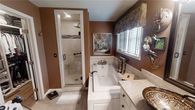 7404 Bonney Hill Rd, Hamilton, NY 13346 - full bathroom featuring a shower stall, vanity, a jetted tub, a walk in closet, and tile patterned floors