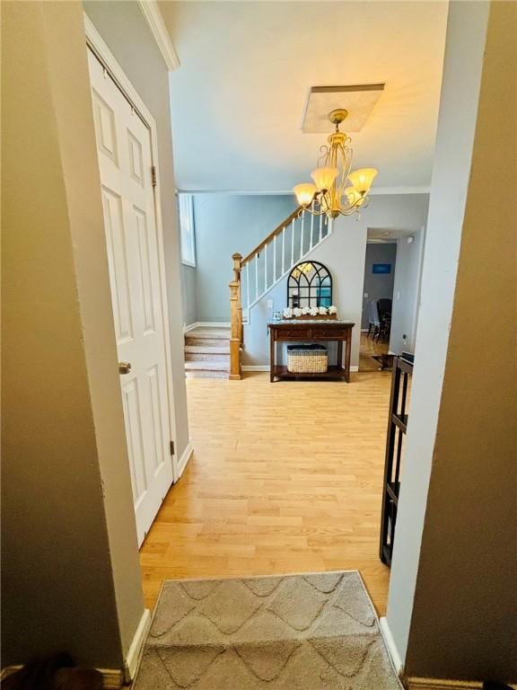 145 Decatur St, Corning-City, NY 14830 - hall with light wood-style flooring, stairway, a chandelier, ornamental molding, and baseboards