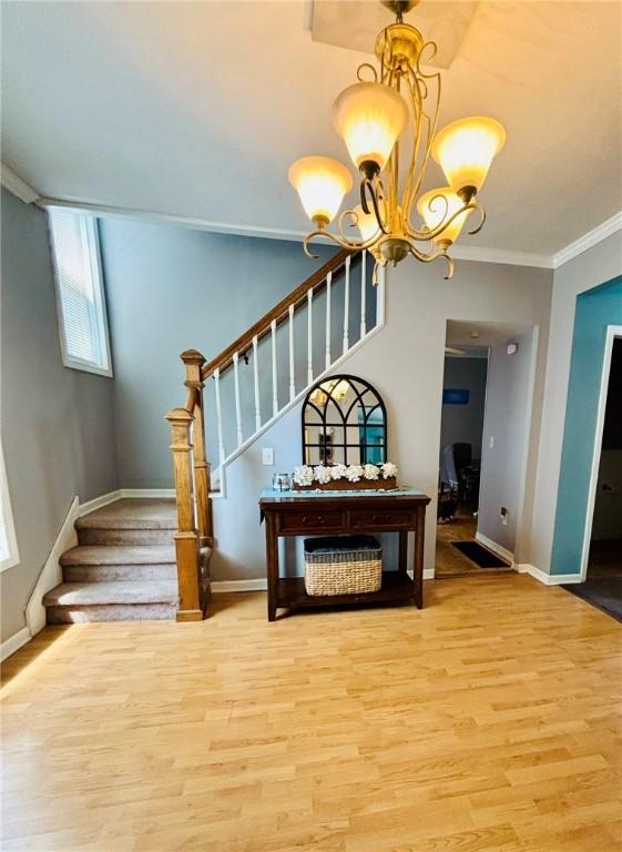 145 Decatur St, Corning-City, NY 14830 - staircase with wood finished floors, baseboards, a chandelier, and crown molding
