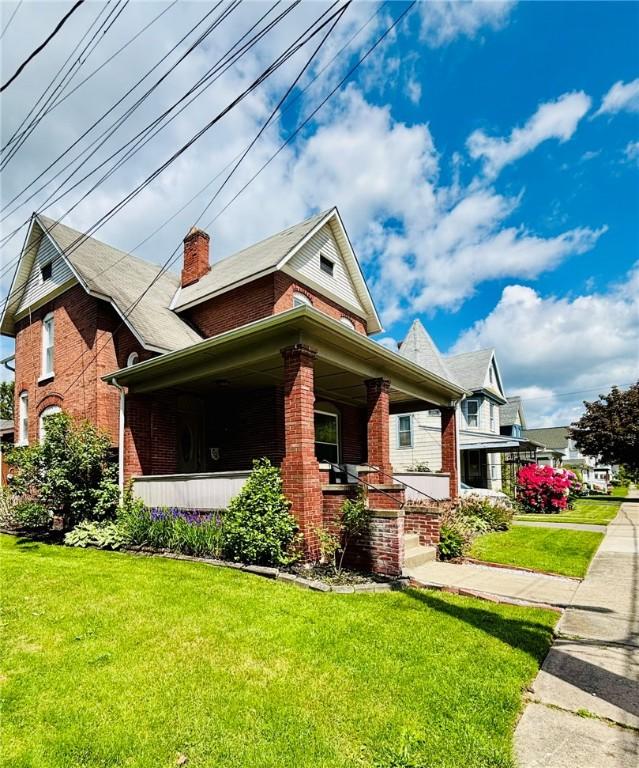 145 Decatur St, Corning-City, NY 14830 - view of front of property with brick siding, a front yard, covered porch, and a chimney