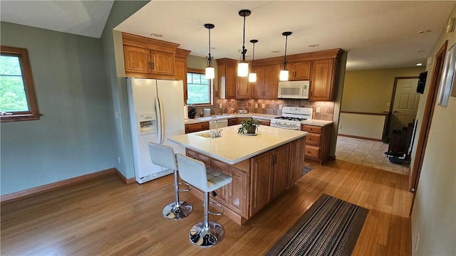 746 Gospel Hill Rd, Guilford, NY 13780 - kitchen featuring white appliances, wood finished floors, light countertops, a breakfast bar area, and recessed lighting
