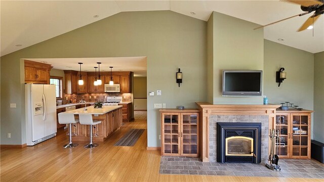 746 Gospel Hill Rd, Guilford, NY 13780 - living area featuring ceiling fan, light wood-style floors, a tiled fireplace, and high vaulted ceiling