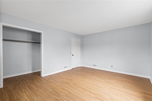 2200 W Henrietta Rd, Brighton, NY 14623 - unfurnished bedroom featuring wood finished floors, baseboards, and two closets