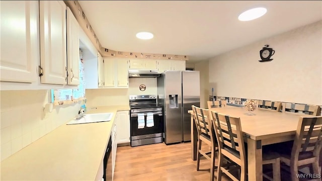 48 Presidio Pl, Amherst, NY 14221 - kitchen with stainless steel appliances, under cabinet range hood, a sink, light countertops, and light wood-style floors