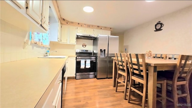 48 Presidio Pl, Amherst, NY 14221 - kitchen with appliances with stainless steel finishes, under cabinet range hood, light countertops, light wood finished floors, and white cabinetry