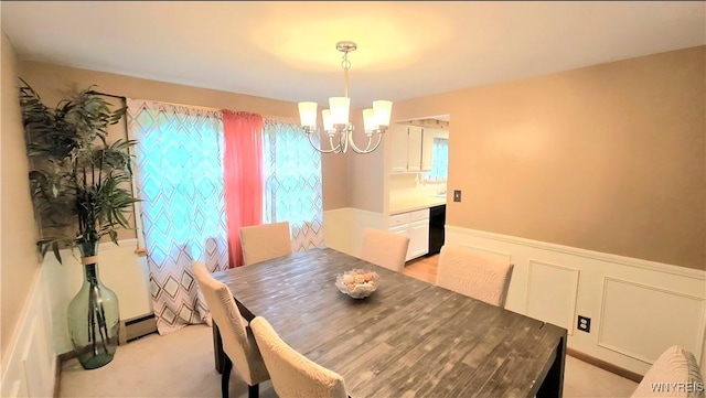 48 Presidio Pl, Amherst, NY 14221 - dining room featuring a chandelier, wainscoting, a baseboard heating unit, a decorative wall, and light colored carpet
