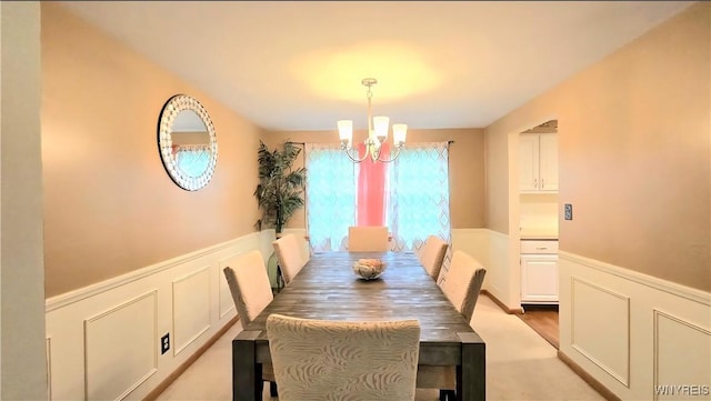 48 Presidio Pl, Amherst, NY 14221 - dining space with a chandelier, a wainscoted wall, and a decorative wall
