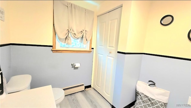 48 Presidio Pl, Amherst, NY 14221 - bathroom featuring a baseboard heating unit, toilet, and wood finished floors