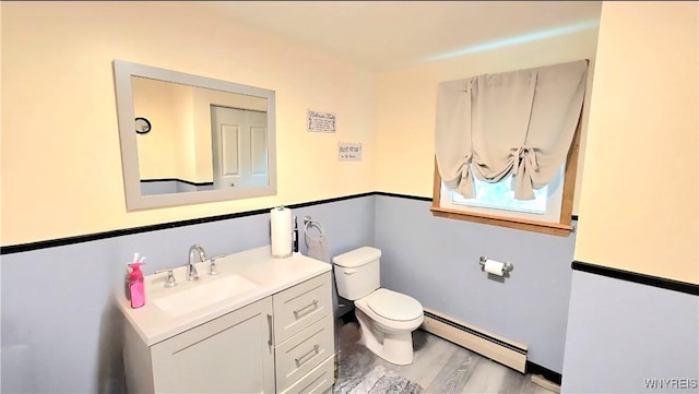48 Presidio Pl, Amherst, NY 14221 - bathroom featuring baseboard heating, toilet, wood finished floors, and vanity
