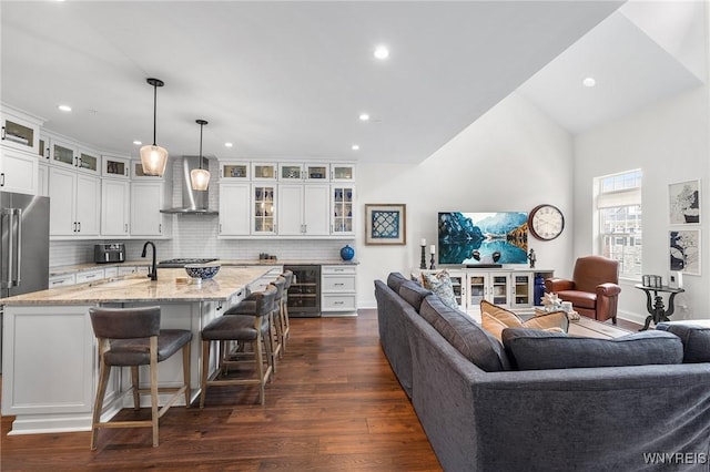 107 California Dr Unit G, Amherst, NY 14221 - kitchen with beverage cooler, wall chimney exhaust hood, open floor plan, backsplash, and recessed lighting