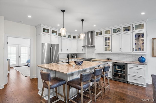 107 California Dr Unit G, Amherst, NY 14221 - kitchen with high quality fridge, wine cooler, wall chimney range hood, backsplash, and white cabinets