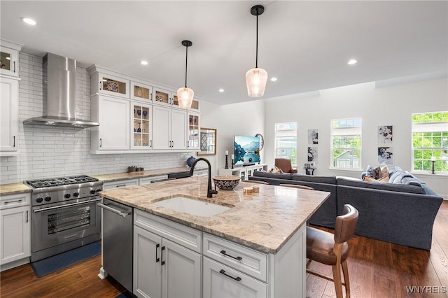107 California Dr Unit G, Amherst, NY 14221 - kitchen with wall chimney exhaust hood, appliances with stainless steel finishes, a sink, open floor plan, and recessed lighting
