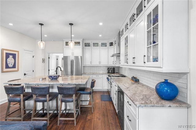 107 California Dr Unit G, Amherst, NY 14221 - kitchen featuring high end fridge, light stone countertops, white cabinetry, a breakfast bar area, and dark wood-style floors
