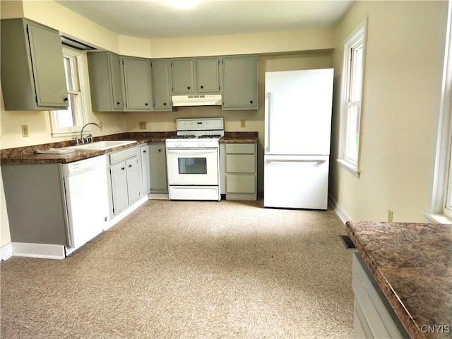 768 Crow Hill Rd, Skaneateles, NY 13152 - kitchen featuring white appliances, under cabinet range hood, a sink, dark countertops, and baseboards