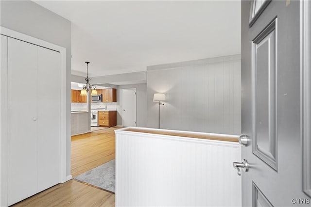 24 The Orch, Manlius, NY 13066 - hallway with light wood-type flooring and a chandelier