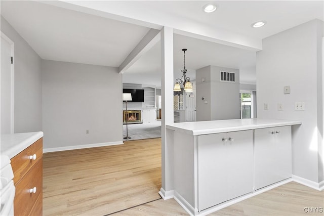 24 The Orch, Manlius, NY 13066 - kitchen featuring baseboards, a warm lit fireplace, light wood-type flooring, light countertops, and recessed lighting