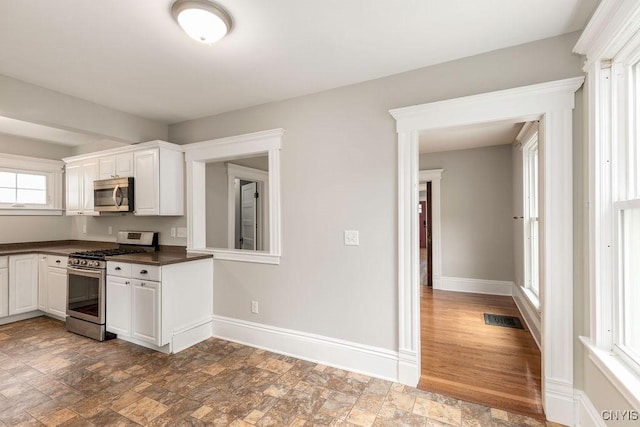 264 S 5th St, Fulton, NY 13069 - kitchen featuring stainless steel appliances, dark countertops, stone finish floors, and baseboards