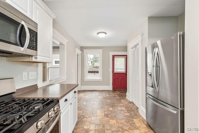 264 S 5th St, Fulton, NY 13069 - kitchen featuring appliances with stainless steel finishes, stone finish flooring, dark countertops, and white cabinetry